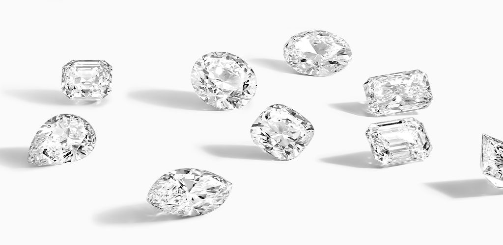 Loose white diamonds in various cuts on a white background, sparkling and elegant.