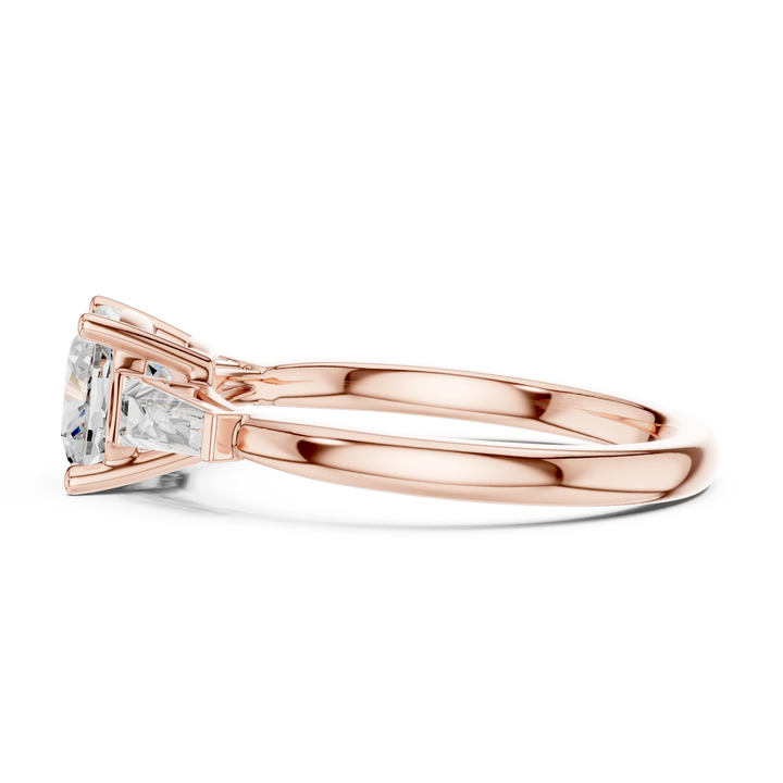Rose gold cushion three-stone ring with tapered baguette side stones side view