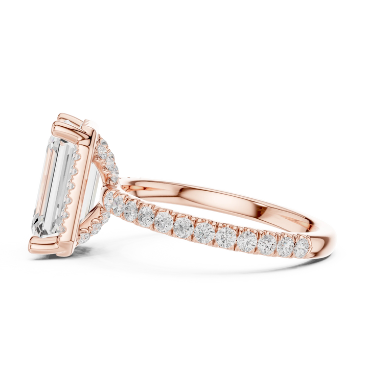 Side view of rose gold emerald cut solitaire ring highlighting hidden halo and thin pavé band design