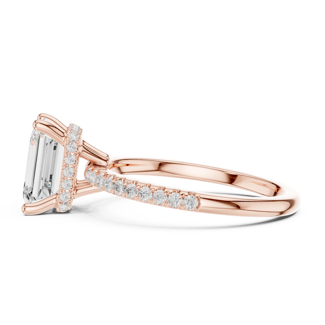 Side view of rose gold emerald cut solitaire ring highlighting thin pave band and prong setting
