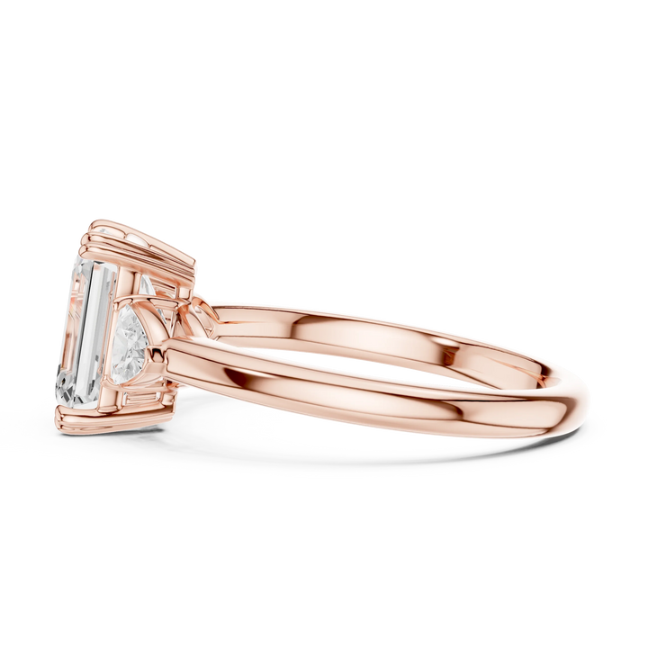 Side view of rose gold emerald three-stone ring with half-moon side stones and lab-grown diamond – Australia