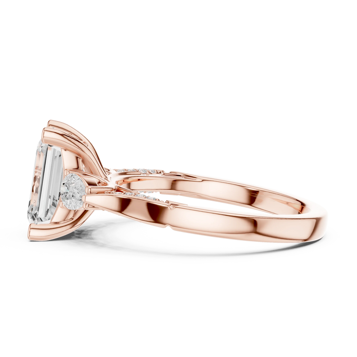 Side view of rose gold emerald three stone ring with pear side stones, accent band and lab-grown diamonds – Australia