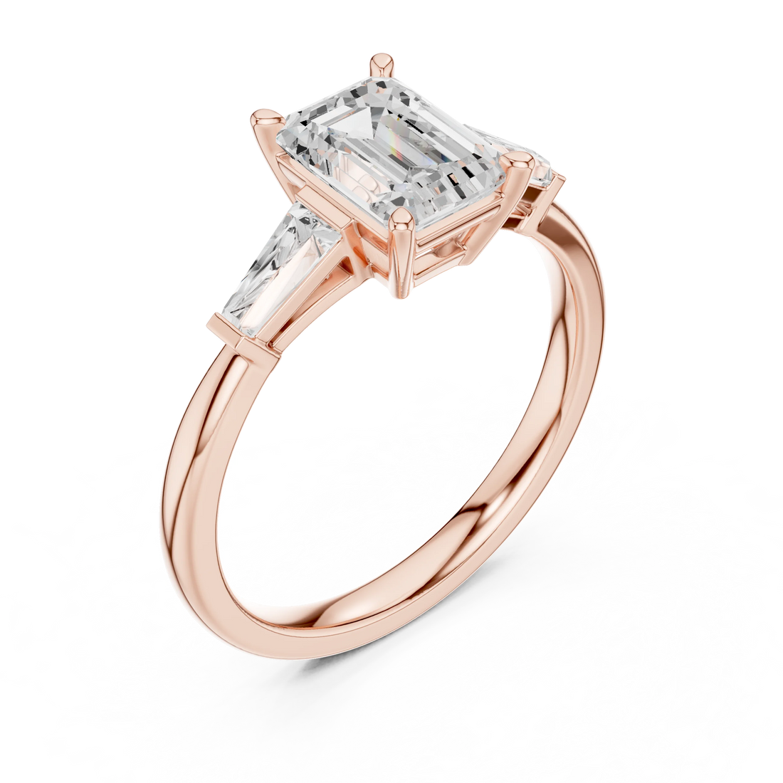 Rose gold emerald three-stone ring with tapered baguette side stones front view