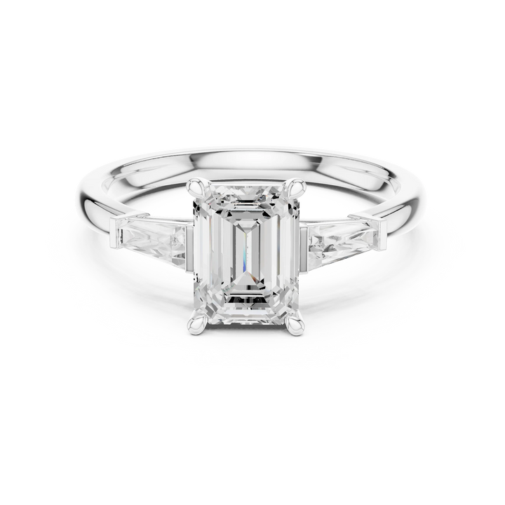 White gold emerald three-stone ring with tapered baguette side stones