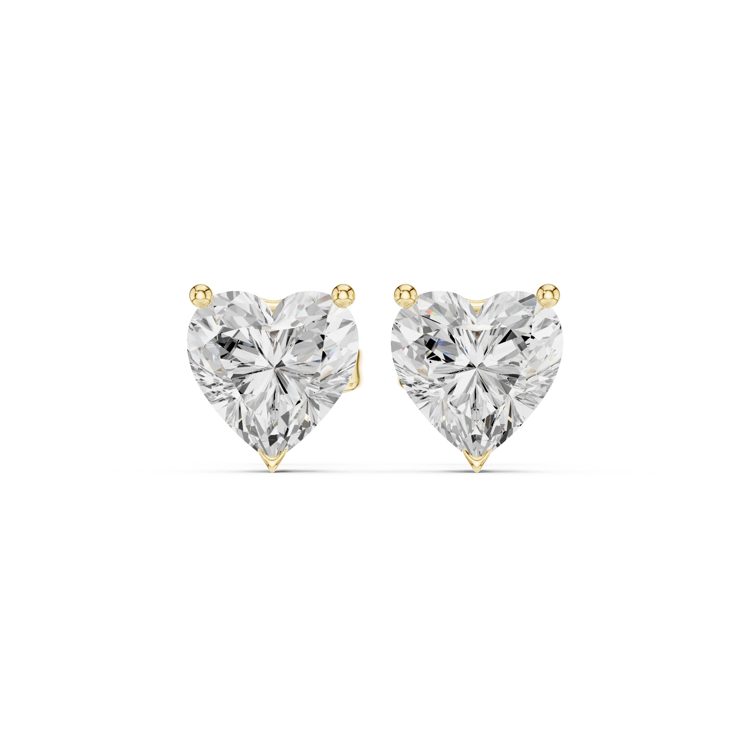 Heart-shaped diamond earrings on a white background in yellow gold