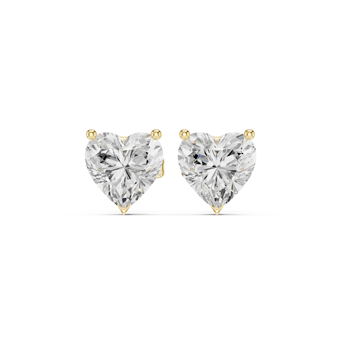 Heart-shaped diamond earrings on a white background in yellow gold