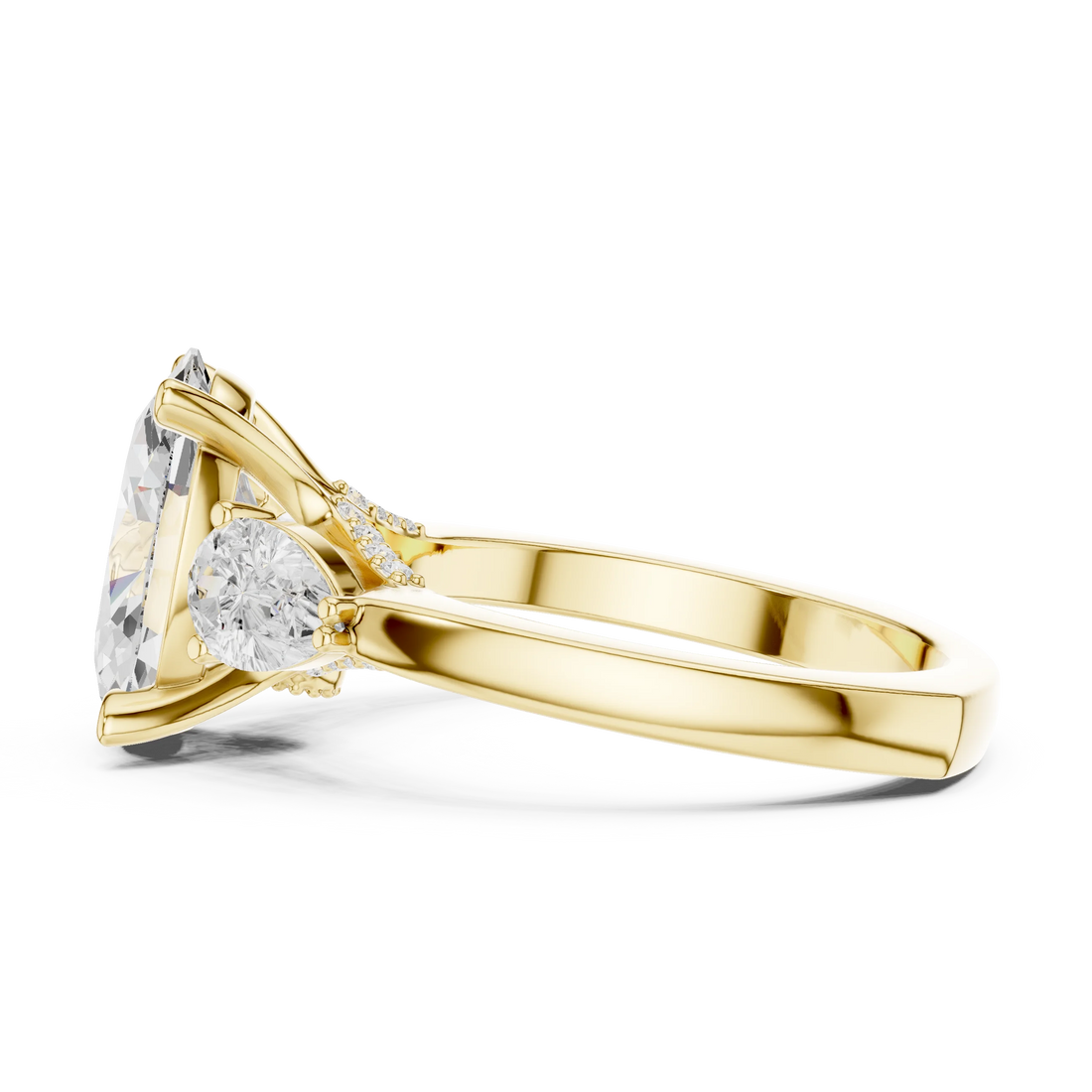 Side profile of yellow gold oval three stone ring highlighting pear side stones and structure