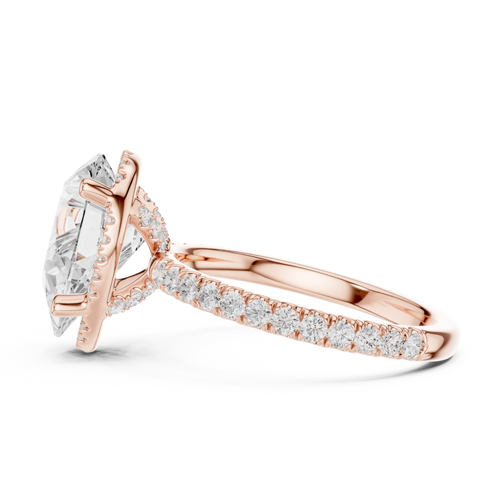 Side view of rose gold pear cut solitaire ring highlighting hidden halo and thin pavé band design