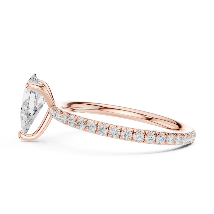 Side profile of rose gold pear cut solitaire ring with thin pavé diamond band and elevated center stone