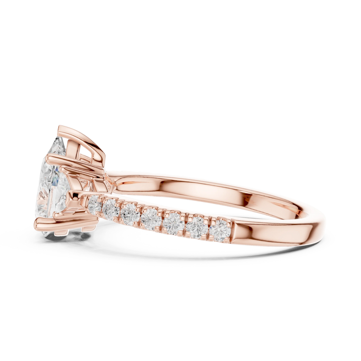 Side view of rose gold pear three stone diamond ring with half moon side stones and pave band, highlighting overall design profile.