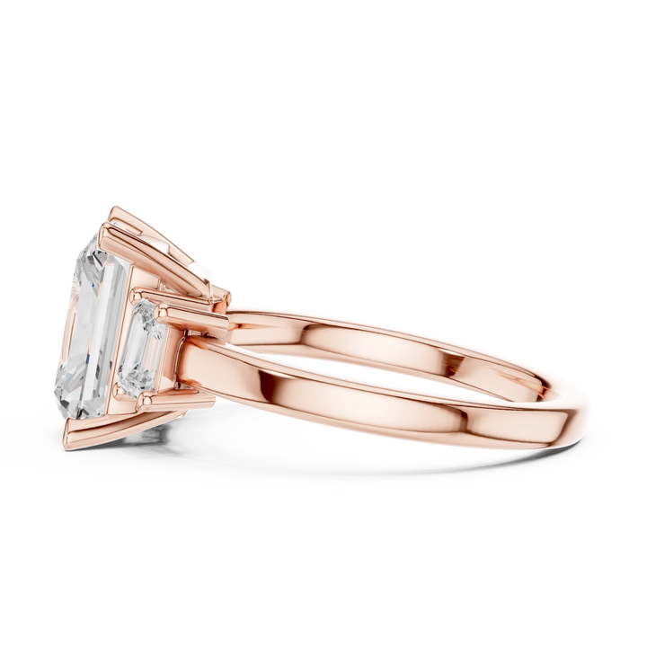 Side view of rose gold radiant three stone ring highlighting step cut trapezoid side stones and diamond setting