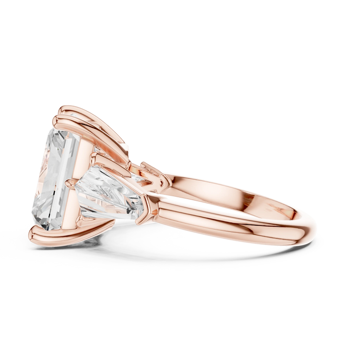 Side view of rose gold radiant three stone ring highlighting trillion side stones and diamond setting