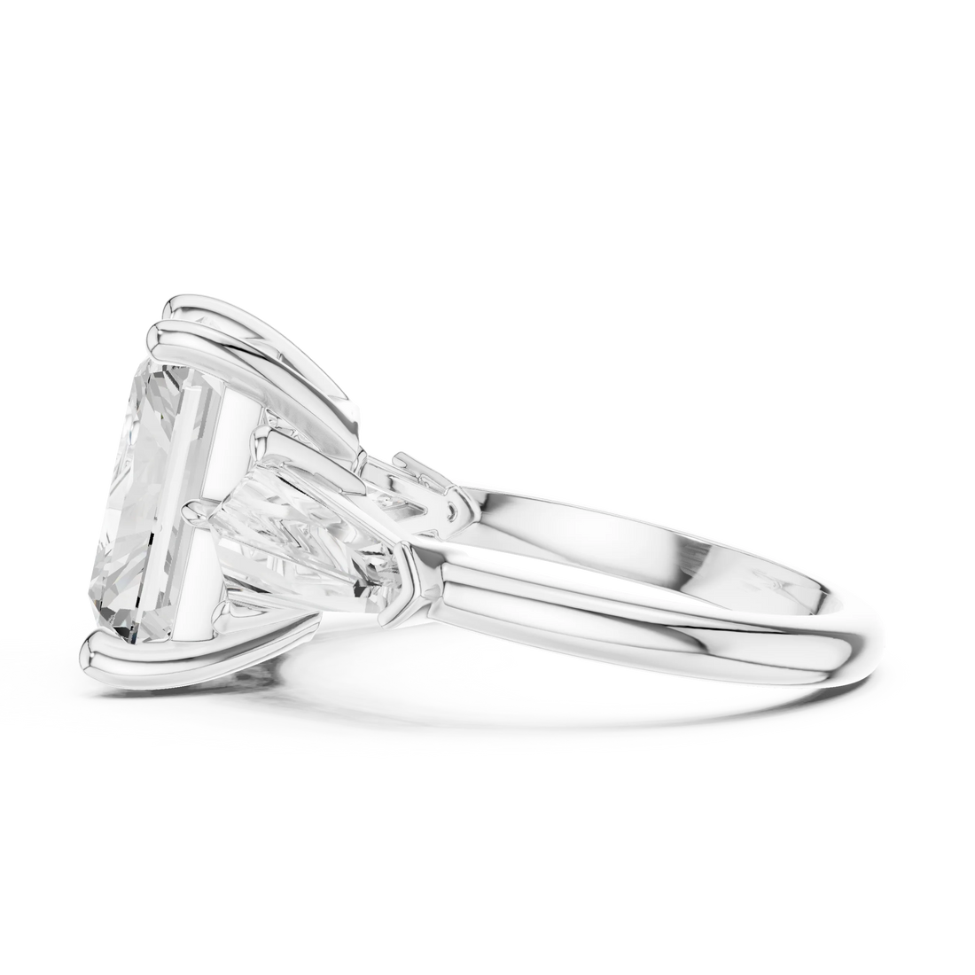 Side view of white gold radiant three stone ring highlighting trillion side stones and diamond setting