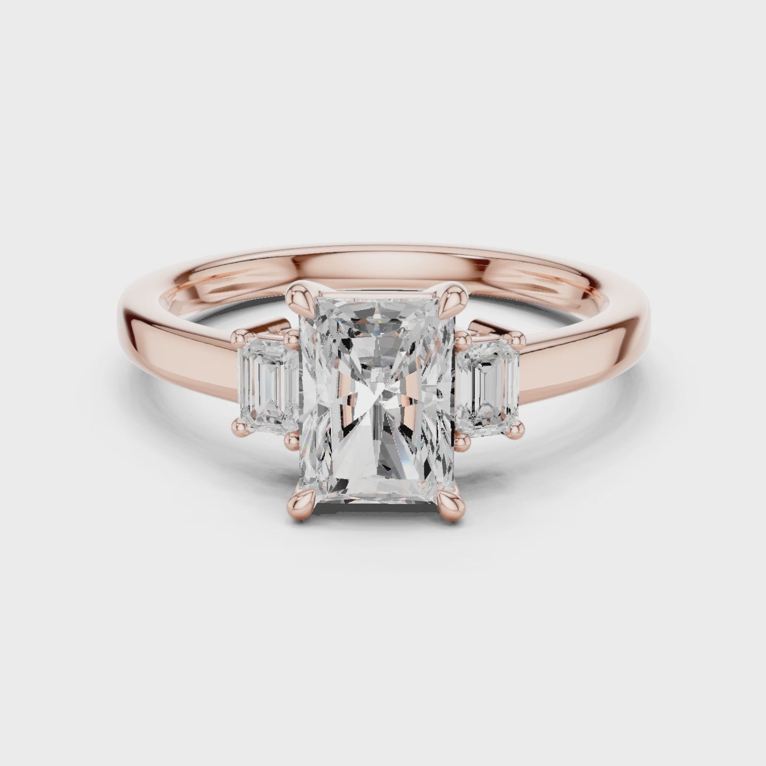 Radiant three stone engagement ring with emerald cut side stones in rose gold, lab grown diamond, Video, Australia DFE