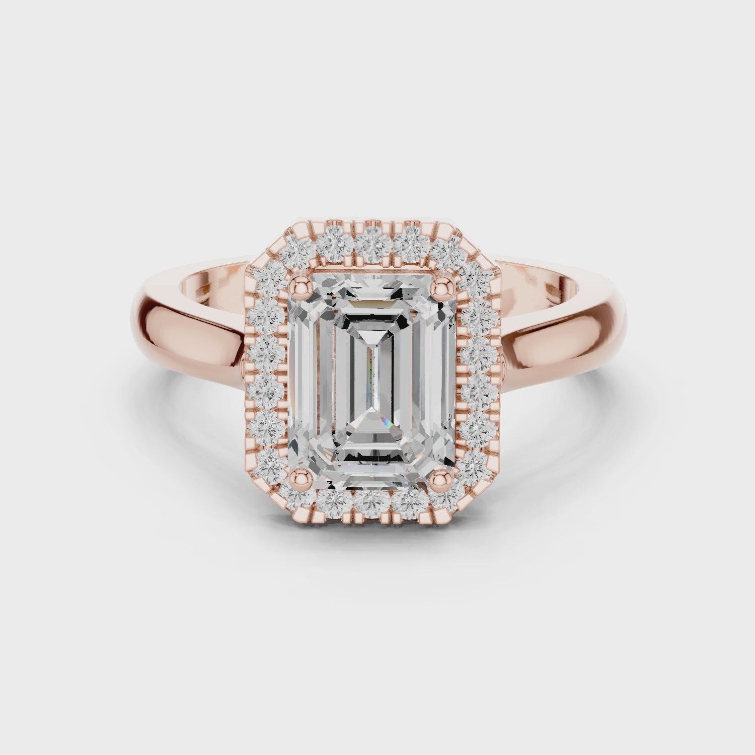 Video of rose gold emerald halo ring highlighting diamond setting and band profile