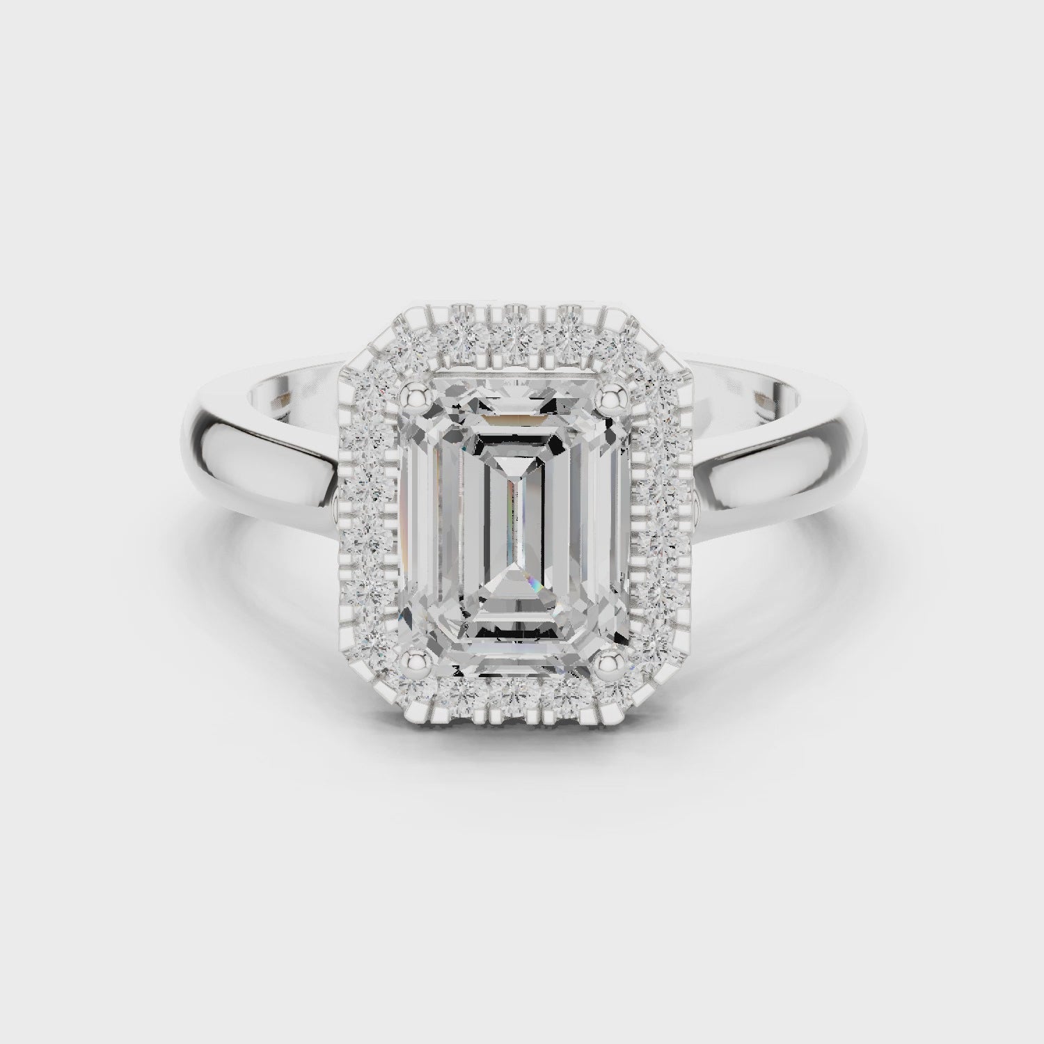Video of white gold emerald halo ring highlighting diamond setting and band profile