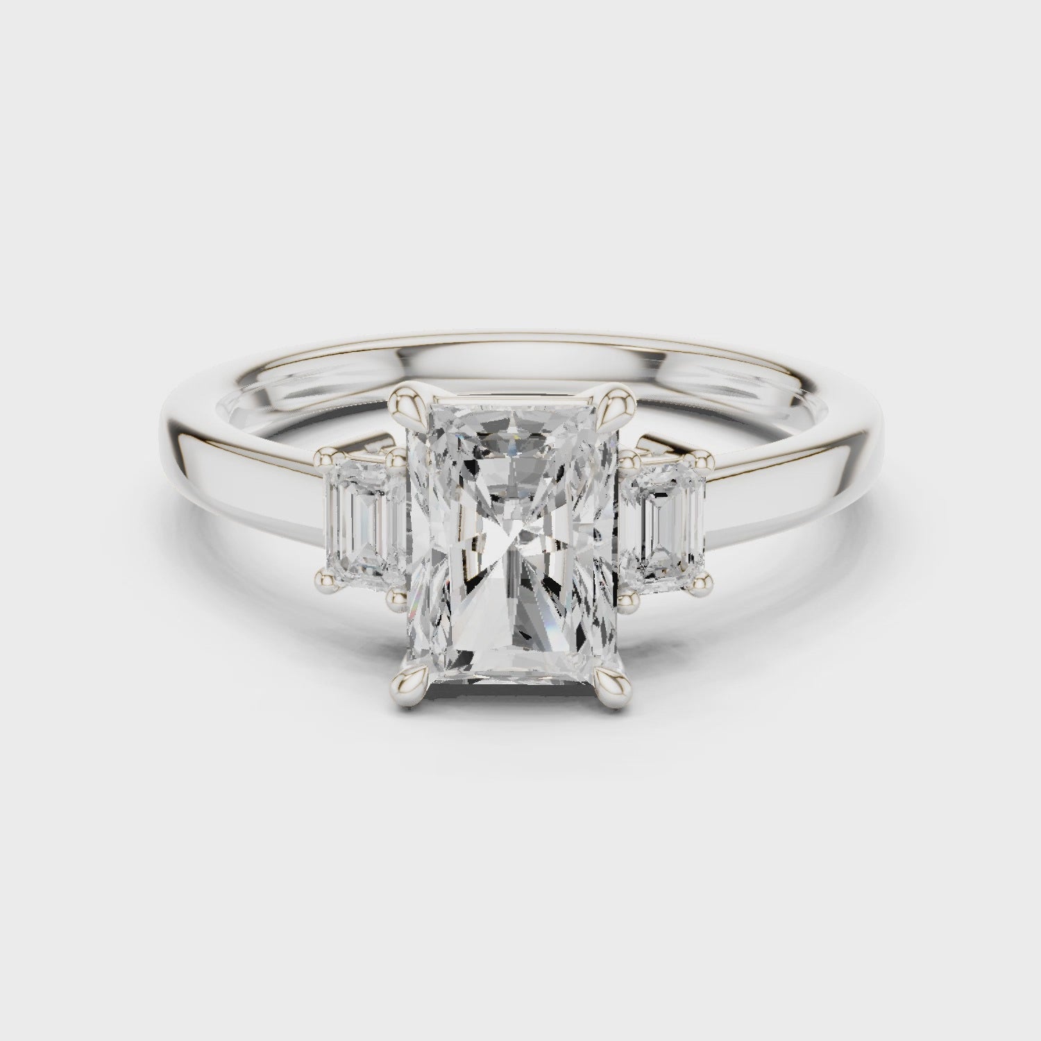 Radiant three stone engagement ring with emerald cut side stones in white gold, lab grown diamond, video, Australia DFE